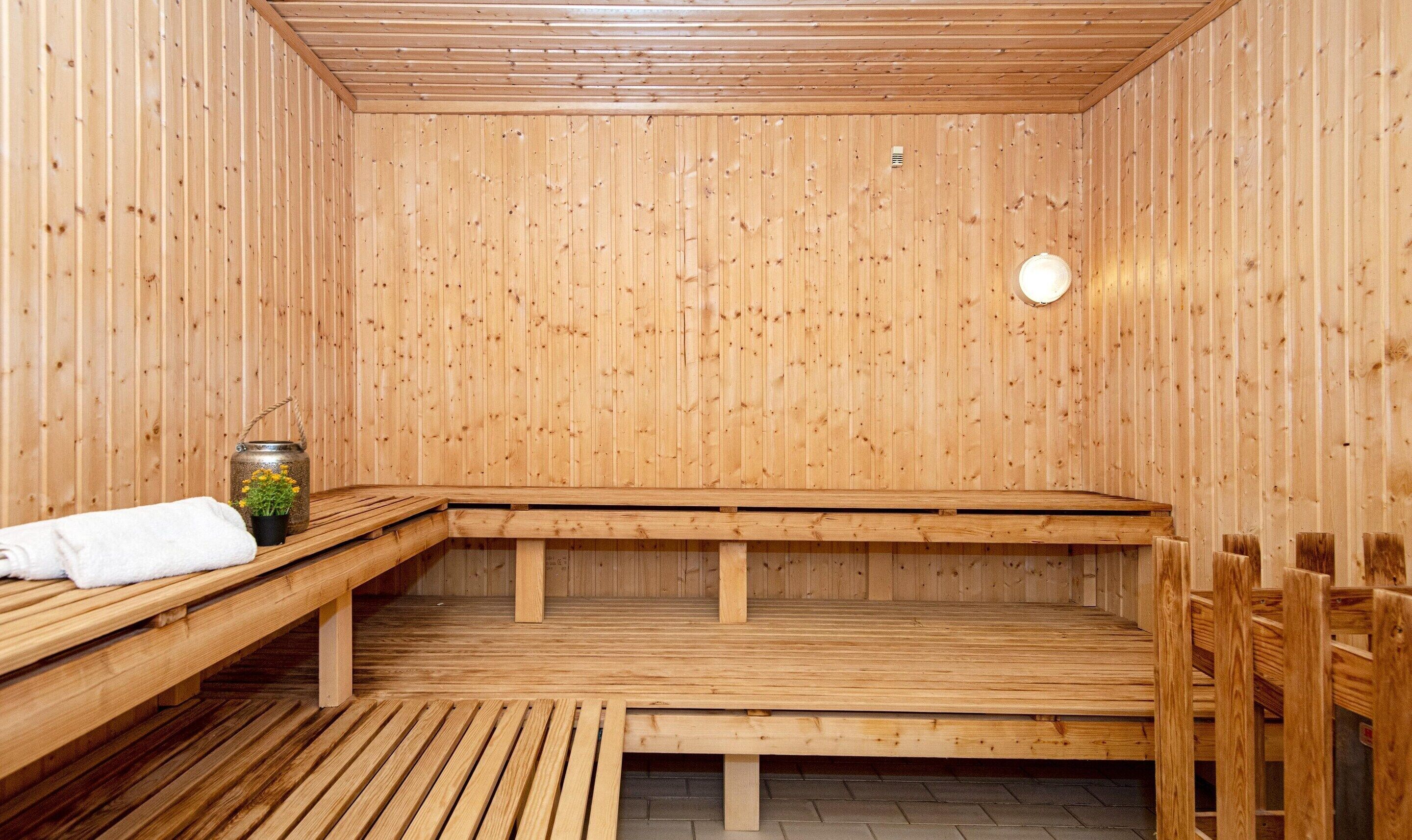 A sauna with wooden benches and a bench with a towel and flowers.