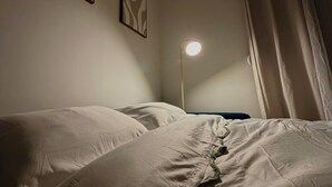 A bedroom with a bed, a bedside lamp, and two wall-mounted abstract paintings. - CosyWellington-Studio near Arras station and center (Achicourt)