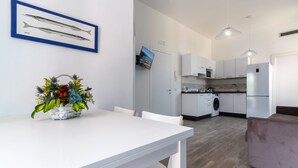 Una cucina moderna con mobili bianchi, forno integrato e frigorifero in acciaio inossidabile.