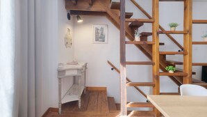 A room with a wooden staircase, a small table with a lamp, and a framed picture on the wall. - Holiday Home “La Perle Rosée” with Private Terrace, and Wi-Fi (Azerat)
