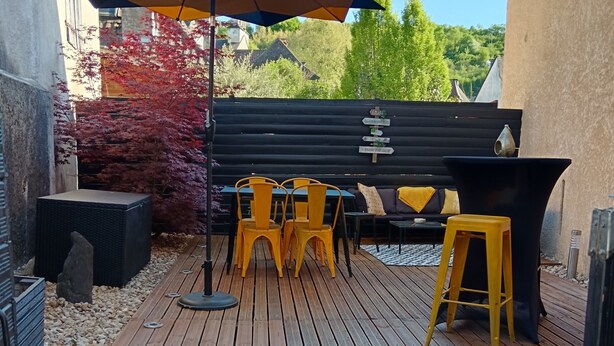 A wooden deck with outdoor furniture, including a table and chairs, and a black piano. - Holiday Home “La Perle Rosée” with Private Terrace, and Wi-Fi (Azerat)