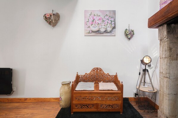 A wooden bed with intricate carvings, a vase, a painting of flowers, and a tripod lamp. - Holiday Home “La Perle Rosée” with Private Terrace, and Wi-Fi (Azerat)