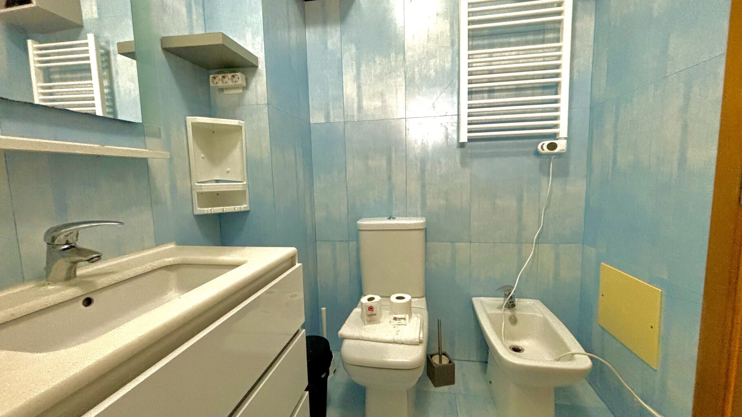 Une salle de bain équipée d’un lavabo, de toilettes, d’un bidet et d’un miroir.