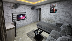 Una sala de estar moderna con un televisor de pantalla plana montado en la pared, un sofá y una mesa de centro.
