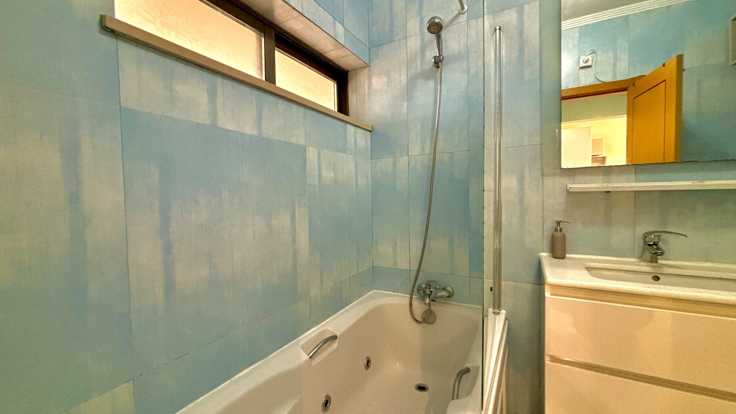 Un baño con bañera, ducha y lavamanos.