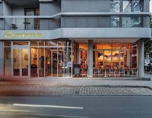A modern building with a cafe named 'Grimm's' on the ground floor. - Grimms Berlin Mitte (Berlin)
