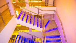 Eine mehrstufige Treppe mit Metallgeländern und blau beleuchteten Stufen.