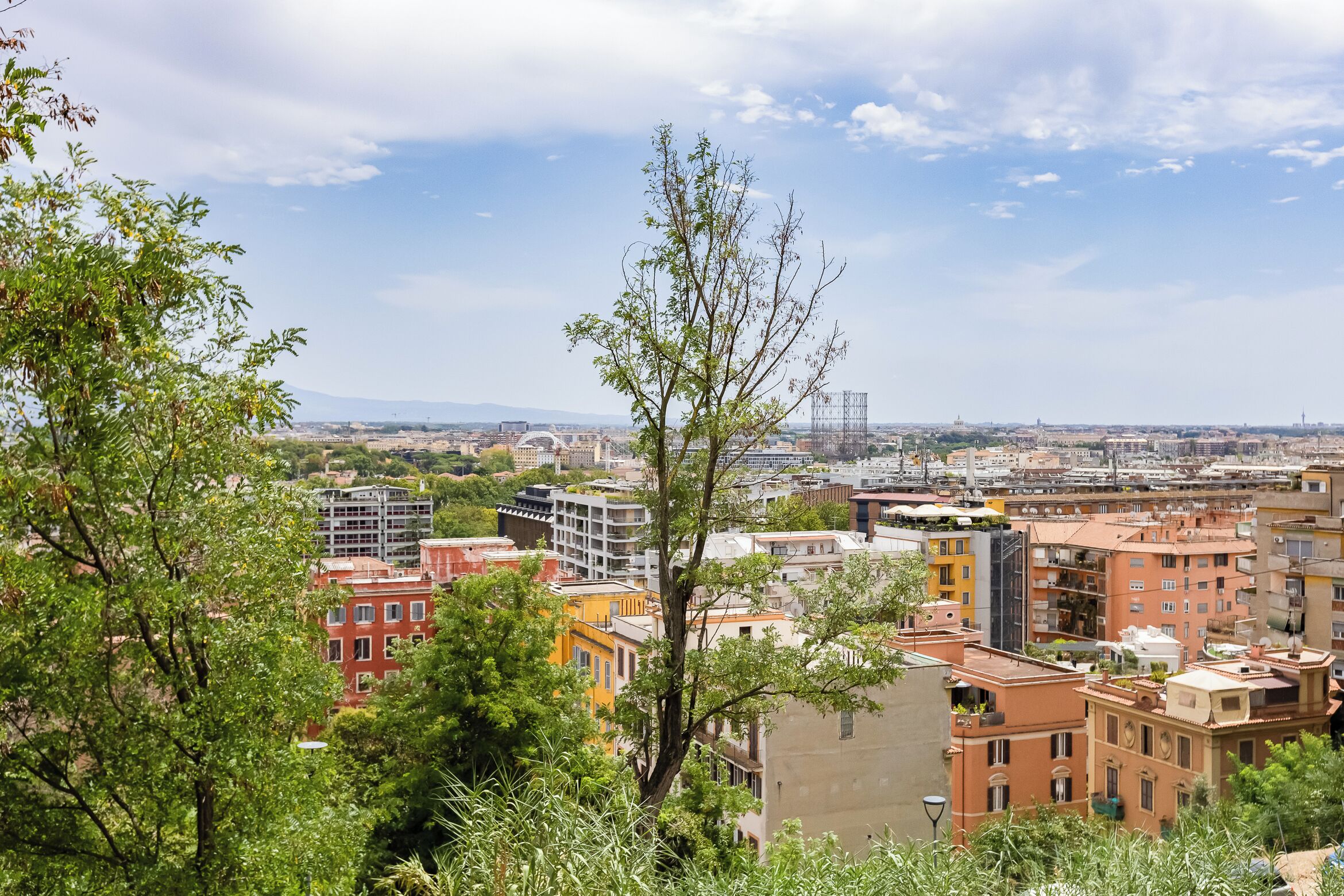 A cityscape with a mix of modern and traditional buildings, including a prominent dome structure in the distance.