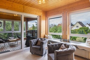 A cozy room with a wooden ceiling, large windows, and a comfortable seating area with two sofas and a chair. - Apartment Gartenblick – Spacious Retreat with Garden View in Korbach (Korbach)