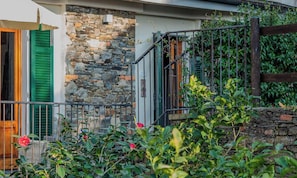 A stone facade, green shutters, and a metal railing. - Camere Giuliano Basso (Vernazza)