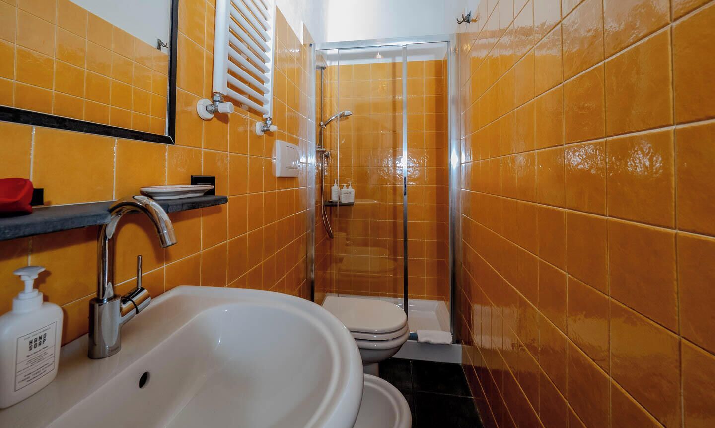 Un bagno con lavandino, WC e doccia.