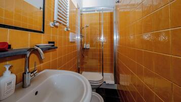 Un baño con lavamanos, inodoro y ducha.