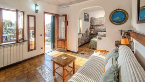 Un salon chaleureux avec un canapé, une petite table et un mur en pierre.