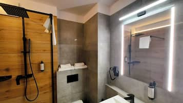 Une salle de bain moderne avec une cabine de douche en bois, un meuble-lavabo intégré avec un miroir et un porte-serviettes fixé au mur.