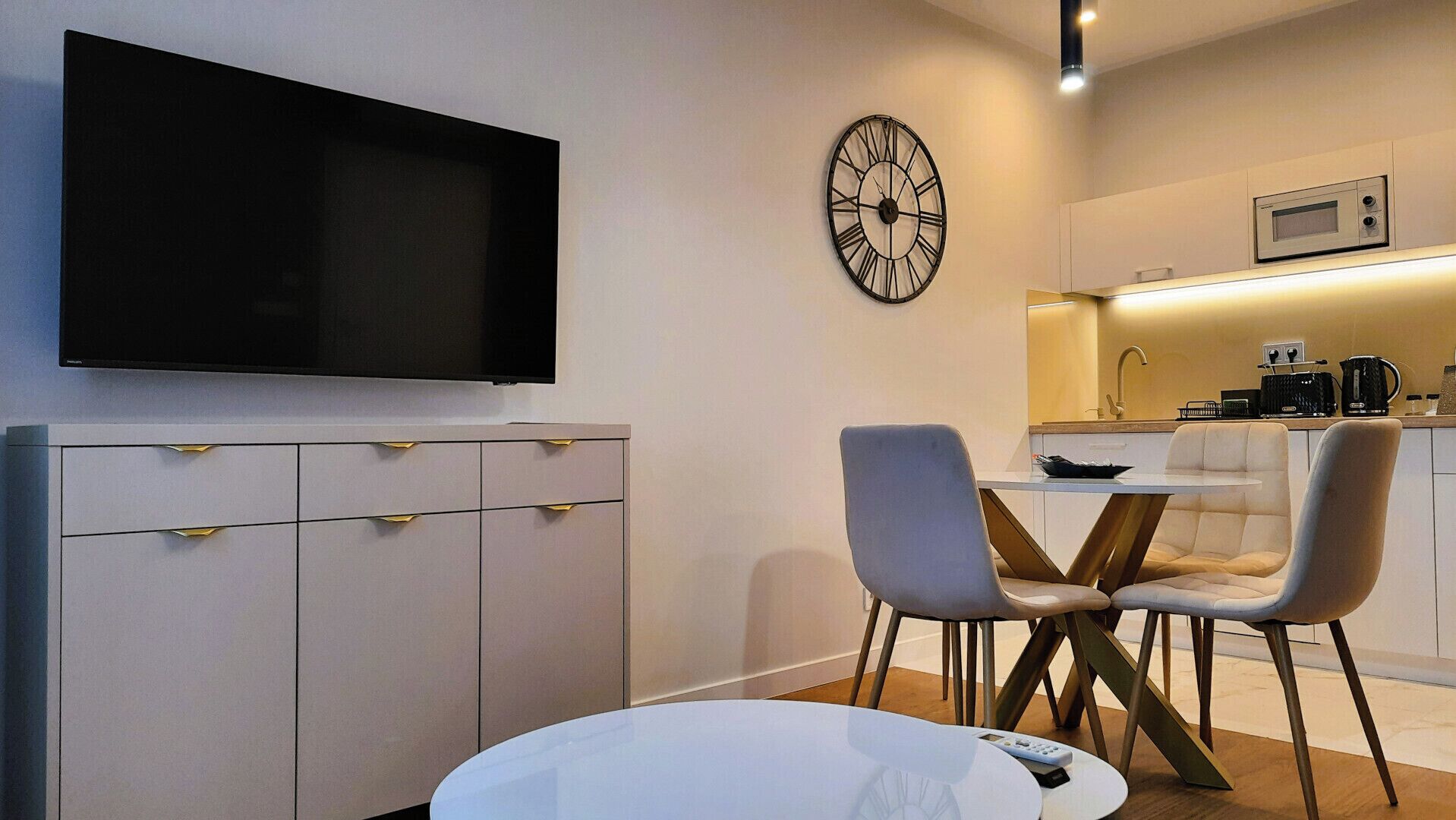 Une cuisine moderne équipée d’un four à micro-ondes, d’un évier et d’une machine à café. Un coin repas avec une table et des chaises est également à disposition.