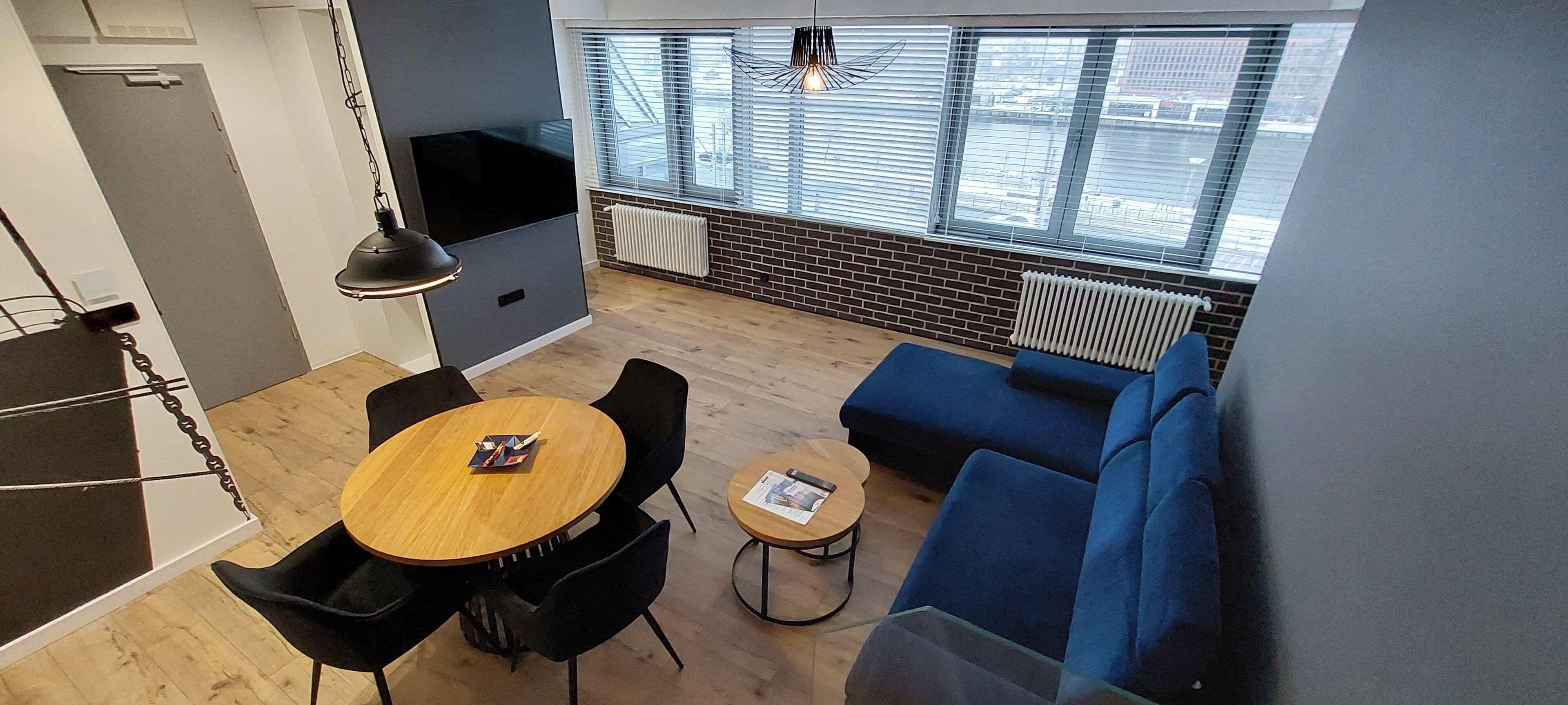 A modern living space with a dining area, a sofa, and a TV.