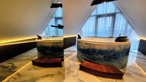 Un área de spa con dos tinas de mármol grandes y escalones de madera.