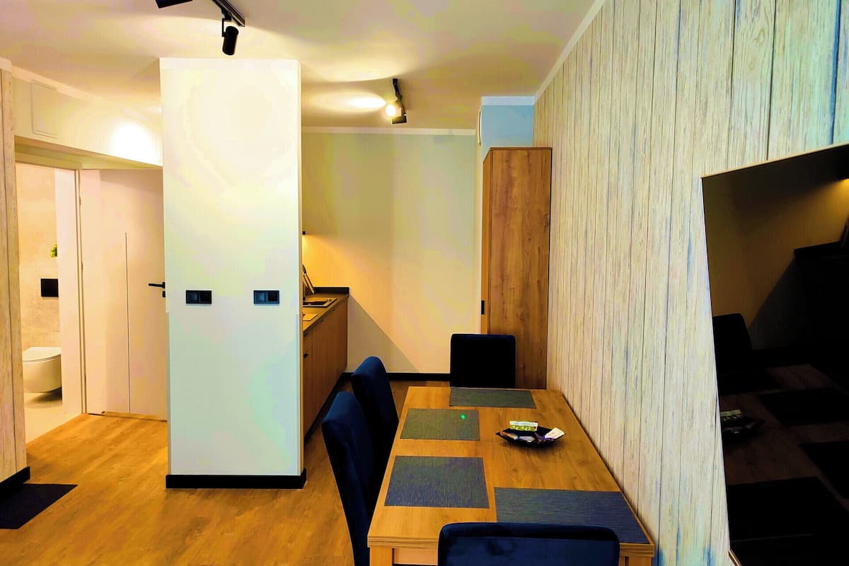A modern kitchen with wooden cabinets, a built-in oven, and a countertop.