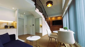 Una sala de estar moderna con una escalera, un comedor y una cocina.