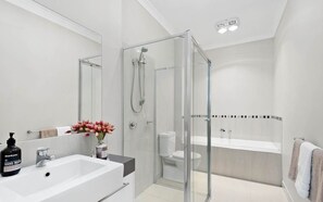 A modern bathroom with a glass-enclosed shower, a white sink, and a toilet. - Modern 3 Bed, 2.5 Bathroom House by the Beach (Seaford)