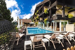Una piscina al aire libre, sombrillas