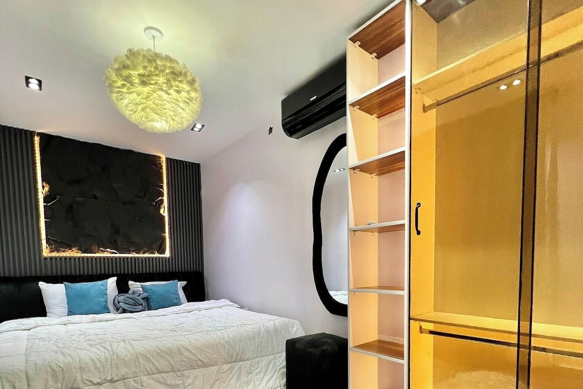 Un dormitorio moderno con cama, armario y una alfombra mullida.