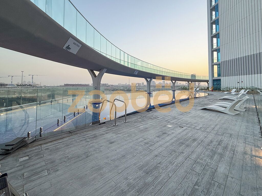 Ein modernes Gebäude mit einem gewölbten Glasgang und Blick auf die Skyline der Stadt.