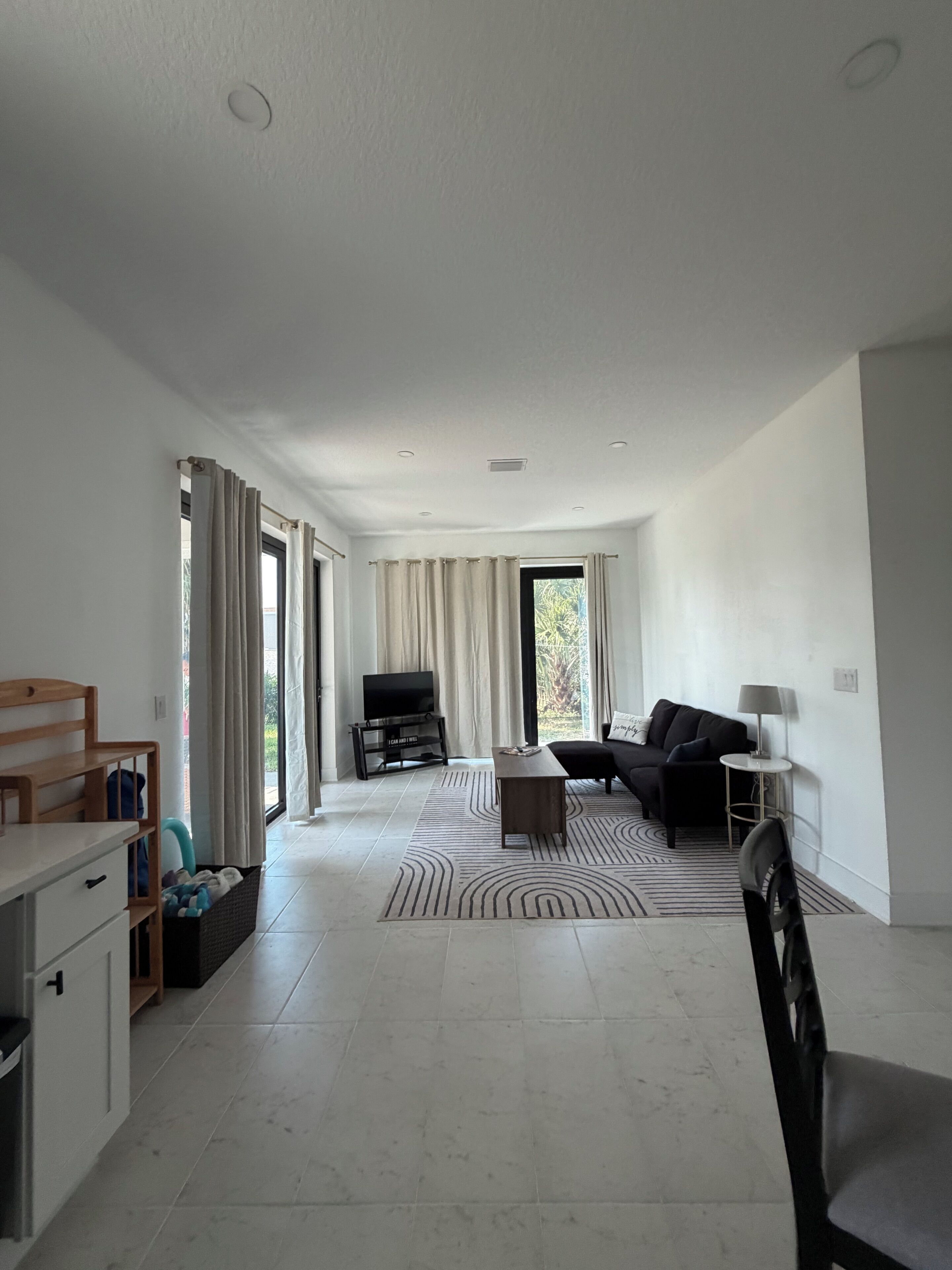 A spacious living area with a sofa, a television, and a coffee table.