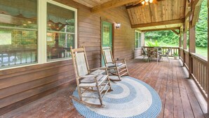 A wooden porch with rocking chairs and a woven rug. - At Birch Hollow, we aim to provide a harmonious blend of tranquility, adventure, and comfort (Stanton)