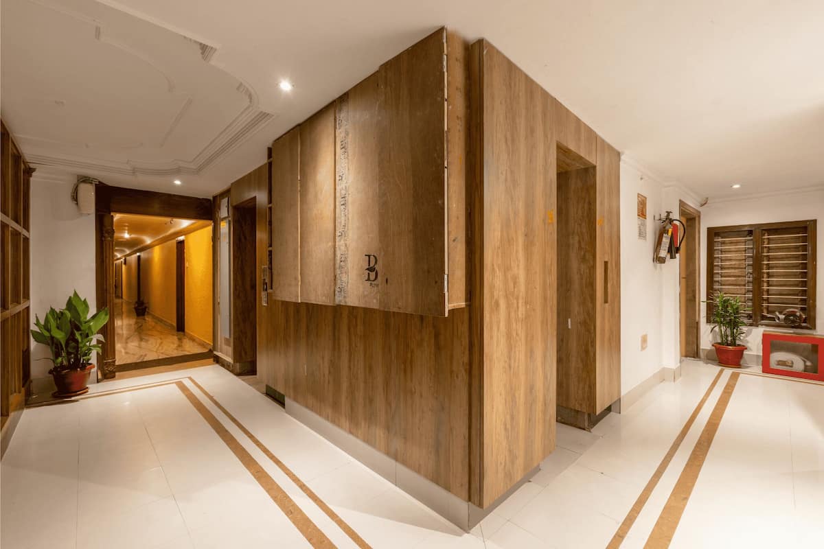 A hallway with wooden paneling, a potted plant, and a fire extinguisher on the wall.