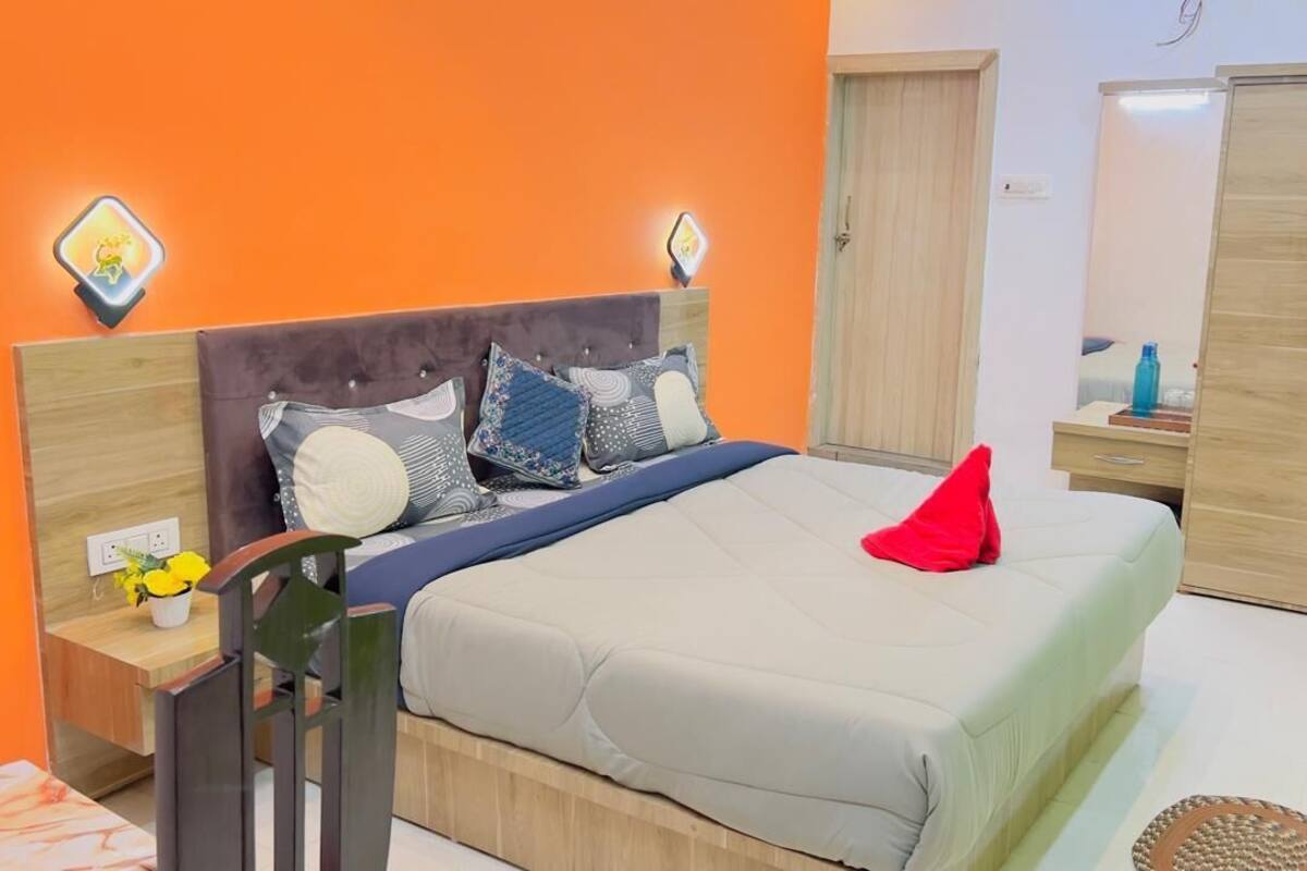 A bedroom with a bed, nightstands, a wardrobe, and a mirror.