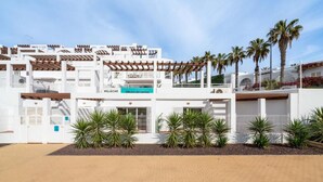 Een modern gebouw met een bord waarop 'MOJACAR Oficina de ventas' staat.