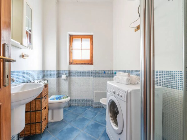 Un baño pequeño con lavabo, inodoro y lavadora.