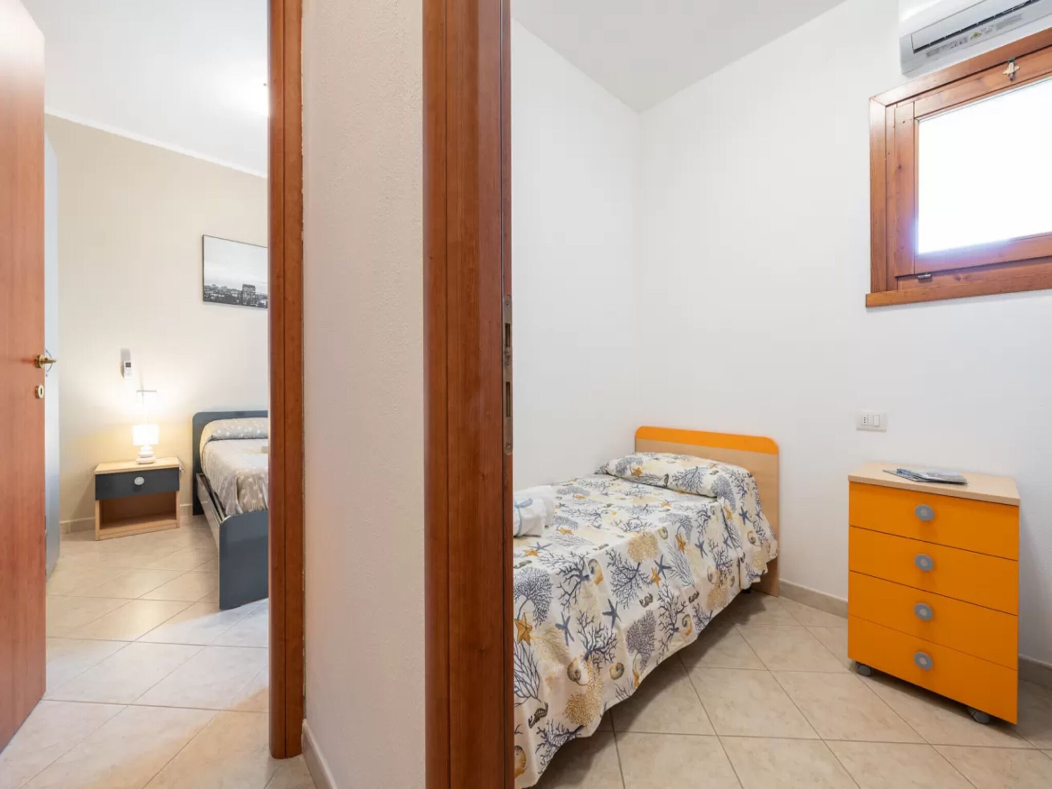 Une chambre à coucher avec un lit, une commode et une table de chevet.