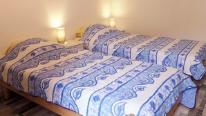 Un letto matrimoniale con biancheria da letto decorata, due abat-jour e una testiera in legno.