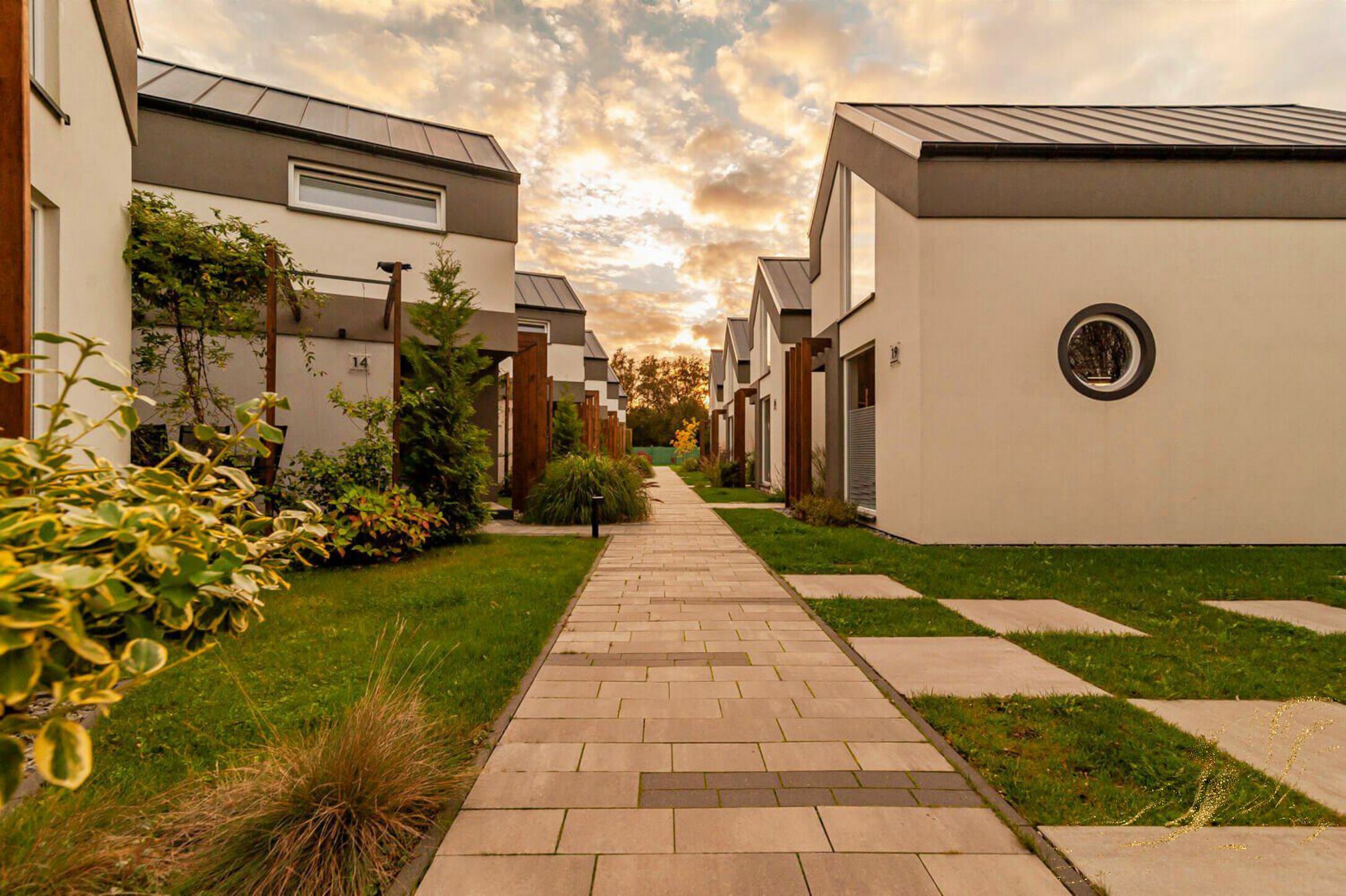 Un sendero que conduce a edificios residenciales modernos bajo un cielo despejado.