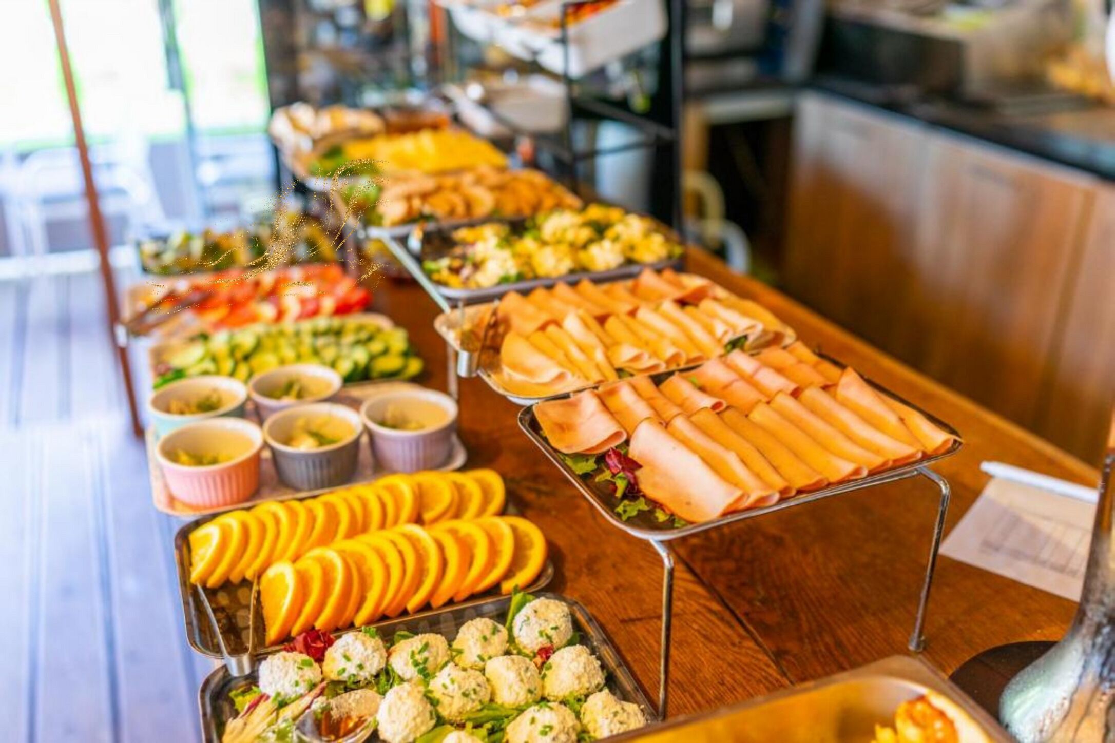 Buffet com diversos alimentos, incluindo frutas, vegetais e pratos com carne.