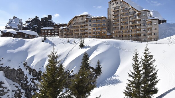A large hotel with multiple floors and balconies, surrounded by snow-covered mountains and trees. - Avoriaz 1800 Apartment 4/5 p (Morzine)