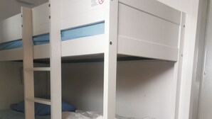 A bunk bed with a blue mattress and white bedding, a white wall, and a striped carpet. - Avoriaz 1800 Apartment 4/5 p (Morzine)