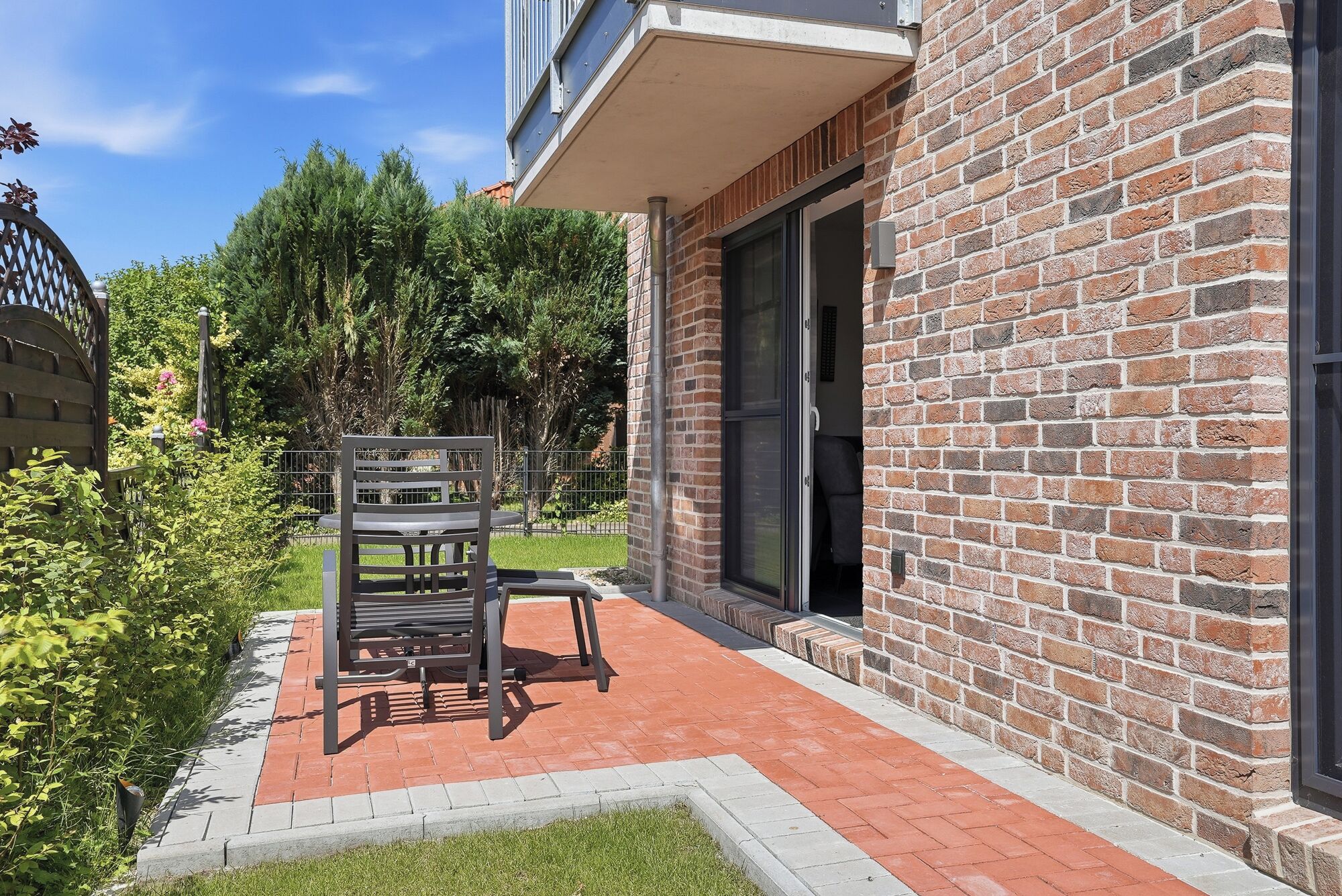 A brick building with a patio area featuring a bench and a table.