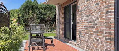 A brick building with a patio area featuring a bench and a table.