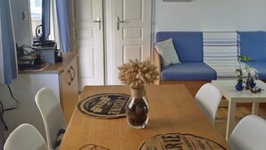 A compact living space with a dining table, chairs, a sofa, and a small kitchenette area. - Seasonal rental fully equipped mobile home for 4/6 people (Saint-Hilaire-de-Riez)