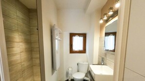 Ein Badezimmer mit Dusche, Toilette und Waschbecken.