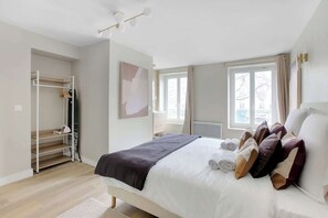 Ein Schlafzimmer mit Bett, Kleiderschrank, Fenster und Heizkörper.