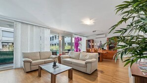 Ein geräumiges Wohnzimmer mit einer Sofagarnitur, einem Couchtisch und einem Essbereich mit einem Holztisch und Stühlen.