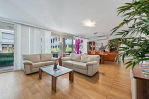 Ein geräumiges Wohnzimmer mit einer Sofagarnitur, einem Couchtisch und einem Essbereich mit einem Holztisch und Stühlen.