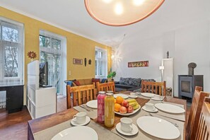 Un coin repas avec une table mise pour le petit-déjeuner, un canapé et une cheminée.