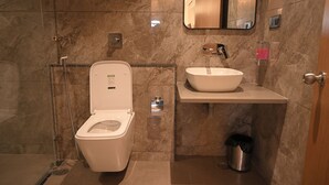 Ein modernes Badezimmer mit Toilette, Waschbecken und Dusche.