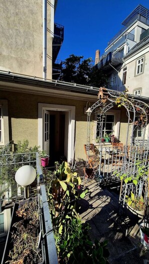 A residential area with a metal pergola, potted plants, and a small garden area. - Studio mit Balkon, im Zentrum, Klimaanlage (Vienna)