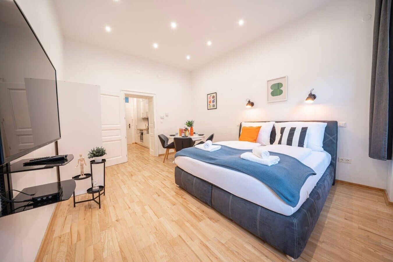 Une chambre moderne avec un grand lit, un bureau et un téléviseur.